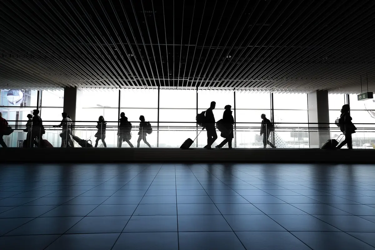 Travelers silhouetted in an airport terminal