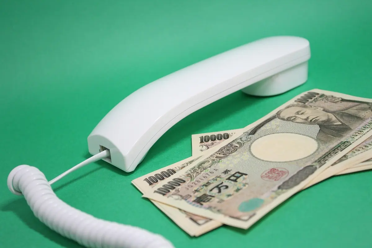 一万円札と電話の受話器